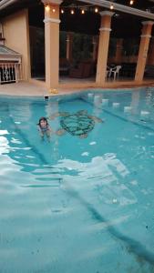 a person swimming in a swimming pool at Villa Lapa 5 near the Guacalillo Rock in Tivives