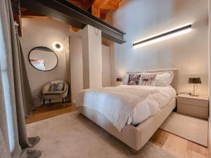 a bedroom with a bed and a mirror and a chair at Suite Boisée - Poluc Apartments Trilocale in Champoluc