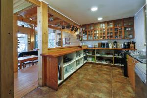 een grote keuken met houten kasten en een aanrecht bij Casa Orilla Lago Rupanco in Isla Cabras