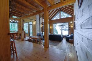 een grote woonkamer met houten vloer en een woonkamer bij Casa Orilla Lago Rupanco in Isla Cabras