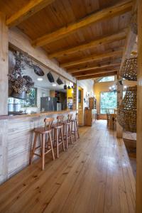 een keuken met houten vloeren en een bar met krukken bij Casa Orilla Lago Rupanco in Isla Cabras