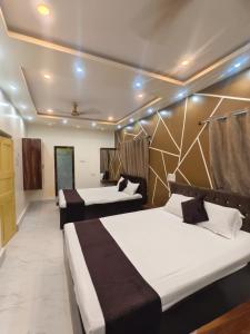 a hotel room with two beds in it at Balaji Guest House in Jhārgrām
