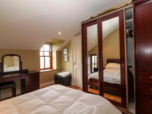 a bedroom with a bed and a desk and a mirror at Johnson's Cottage in Brandon