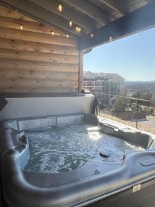 a hot tub in a patio with a wooden wall at New Log Cabin with Ozark Sunset Views, $400 Daily Activities Included, Pickleball in Branson