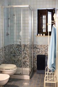 Un baño con inodoro y ducha de cristal. en Villa Carrubo Peroscia by STHEY, en Padresergio