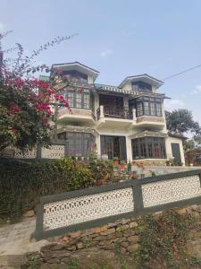 a large house with a bench in front of it at The Bougainvillea House in Takdāh