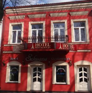 a red building with windows and a hotel at Hotel Sekwana in Częstochowa
