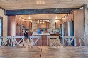 a kitchen with wooden cabinets and a kitchen island with bar stools at Pvt Indoor Pool-Basketball Court-Theatre Room & Hot Tub-Games-Sleeps 46-Table Rock View-Free Tickets in Branson