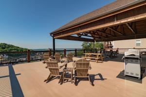 a deck with chairs and tables and a grill at Pvt Indoor Pool-Basketball Court-Theatre Room & Hot Tub-Games-Sleeps 46-Table Rock View-Free Tickets in Branson