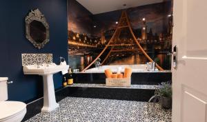 a bathroom with a sink and a bath tub with a picture at St Hildas Complex in Hinderwell