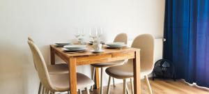 a wooden table with chairs and wine glasses on it at KOMM - Panoramablick - Balkon - Küche - Parkplatz in Suhl