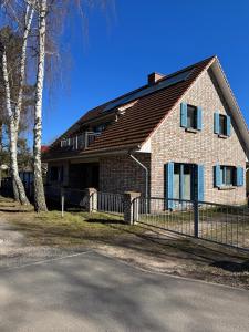 a brick house with a fence in front of it at Haus Ostseeidyll, App 01 in Neuhaus