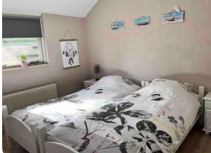 a bedroom with a bed with a black and white comforter at Vakantiewoning 't Linderveld in Rossum