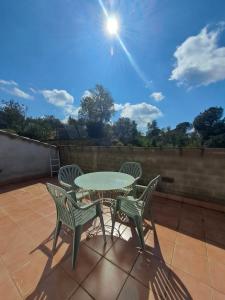 une table et quatre chaises sur la terrasse dans l'établissement Villa Breda, piscina terraza privada, à Terra Brava
