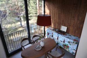 Una mesa y sillas en una habitación con ventana. en Gigi Mountain Home, en Divčibare
