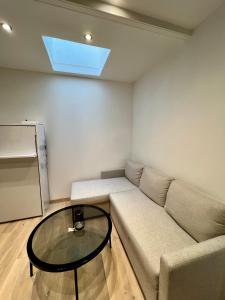 un salon avec un canapé et une table en verre dans l'établissement Appartement, à Neuilly-sur-Seine