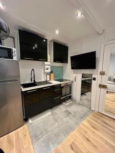 - une cuisine avec des placards noirs et un évier dans l'établissement Appartement, à Neuilly-sur-Seine