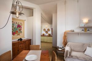 una sala de estar con una mesa y un sofá en Homey Experience - Attic Panorama, en La Maddalena