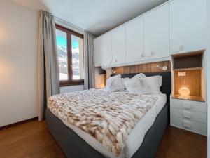 a bedroom with a large bed and a window at Monte Zerbion Retreat - Poluc Apartments trilocale in Champoluc
