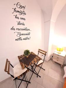 a dining room with a table and a sign on the wall at Il Vicolo b&b in Putignano
