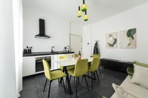 a kitchen and dining room with a table and yellow chairs at Rinascimento Apartments in Florence