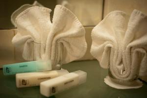 un vaso di vetro con due asciugamani e due spazzolini da denti di Jerusalem Gold Hotel a Gerusalemme