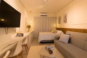 a hotel room with a bed and a couch at Pousada na praia Peruibe - Vila Thaynara in Peruíbe