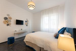 a white bedroom with a bed and a television at Rinascimento Apartments in Florence
