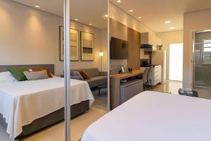 a hotel room with a bed and a desk at Pousada na praia Peruibe - Vila Thaynara in Peruíbe