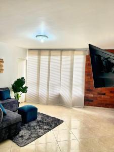 a living room with a couch and a flat screen tv at apartamento en la floresta in Medellín