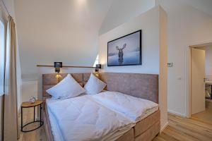 ein Schlafzimmer mit einem großen Bett mit weißer Bettwäsche in der Unterkunft Deluxe Studio-Apartment "Wiking-Koje 11" direkt an der Schlei in Schleswig