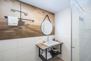 ein Badezimmer mit Waschbecken und Spiegel in der Unterkunft Deluxe Studio-Apartment "Wiking-Koje 11" direkt an der Schlei in Schleswig