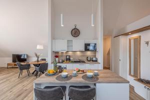 eine Küche und ein Wohnzimmer mit Tisch und Stühlen in der Unterkunft Deluxe Studio-Apartment "Wiking-Koje 11" direkt an der Schlei in Schleswig + 32 Fotos