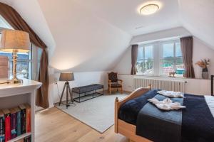 a bedroom with a bed and a chair and windows at Villa Sunside Appartements in Schluchsee +52 photos