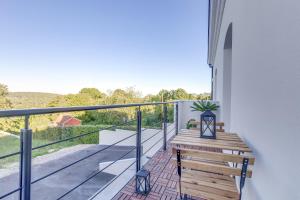 a balcony with a wooden bench and a view at Suite climatisée, 2 personnes in Montry