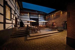 een patio met tafels, stoelen en parasols bij De Pingerhoeve in Nuth