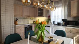 a kitchen with a table with a vase of flowers at Rinch Hill in Regen