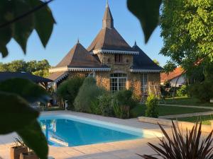 a house with a swimming pool in front of it at Maison d'Hôtes Lassaubatju in Hontanx