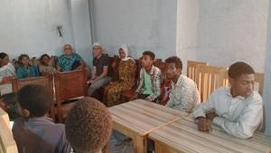 un gruppo di persone seduti intorno a un tavolo in una stanza di Blue Nile Guest House a Lalībela