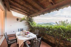 a table and chairs on a patio with a view at Capo Ceraso Family Resort in Costa Corallina