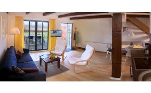 - un salon avec un canapé bleu et des fauteuils blancs dans l'établissement Kinderfreundliche Ferienanlage In Idyllischer Lage, à Neuenkirchen