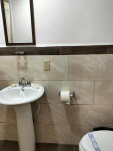 a bathroom with a sink and a toilet and a mirror at hotel economico in Tijuana