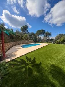 - une piscine au milieu d'une pelouse dans l'établissement Villa Breda, piscina terraza privada, à Terra Brava