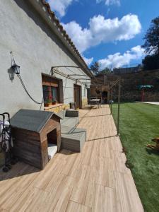 une terrasse en bois avec un banc et une maison dans l'établissement Villa Breda, piscina terraza privada, à Terra Brava