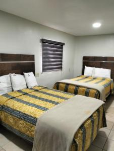 two beds in a hotel room withskirts at hotel economico in Tijuana