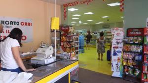 a woman standing at a counter in a supermarket at Residence La Bricola LB 238 in I Casoni