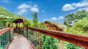 a bridge over a wooden walkway with a hut at Kaz Robinson Cabane Perchee Vue Mer Vivez l aventure Robinson avec le confort d une vue imprenable sur les Caraibes in Terre-de-Bas