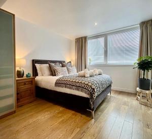 a bedroom with a large bed and a window at Modern Flat overlooking High St in Andover