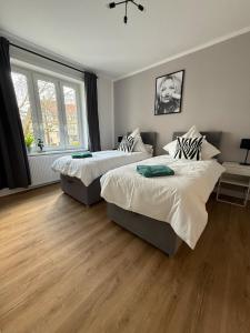 zwei Betten in einem Zimmer mit Holzboden in der Unterkunft Apartment 2 Chic Chamber in Hannover