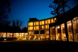 a large building with lit up windows at night at Hotel Azur Premium in Si&oacute;fok
